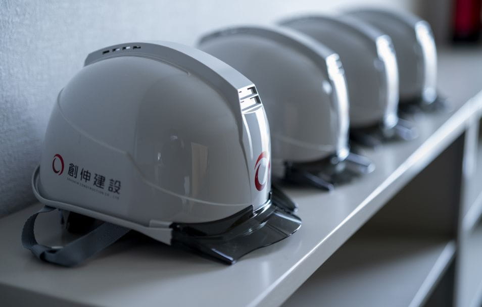 ロゴ入り白いヘルメットが並ぶ様子。